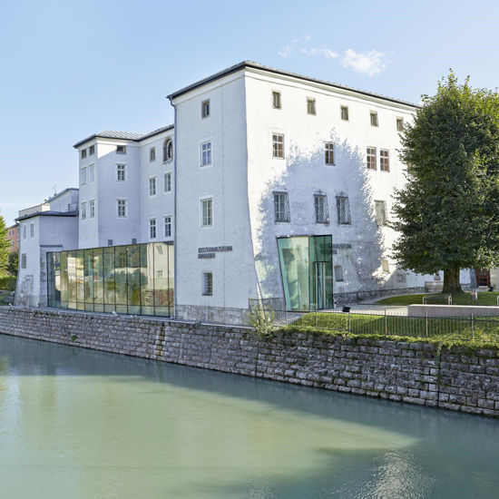 Eine Außenansicht des Keltenmuseum Hallein mit der Salzach im Vordergrund